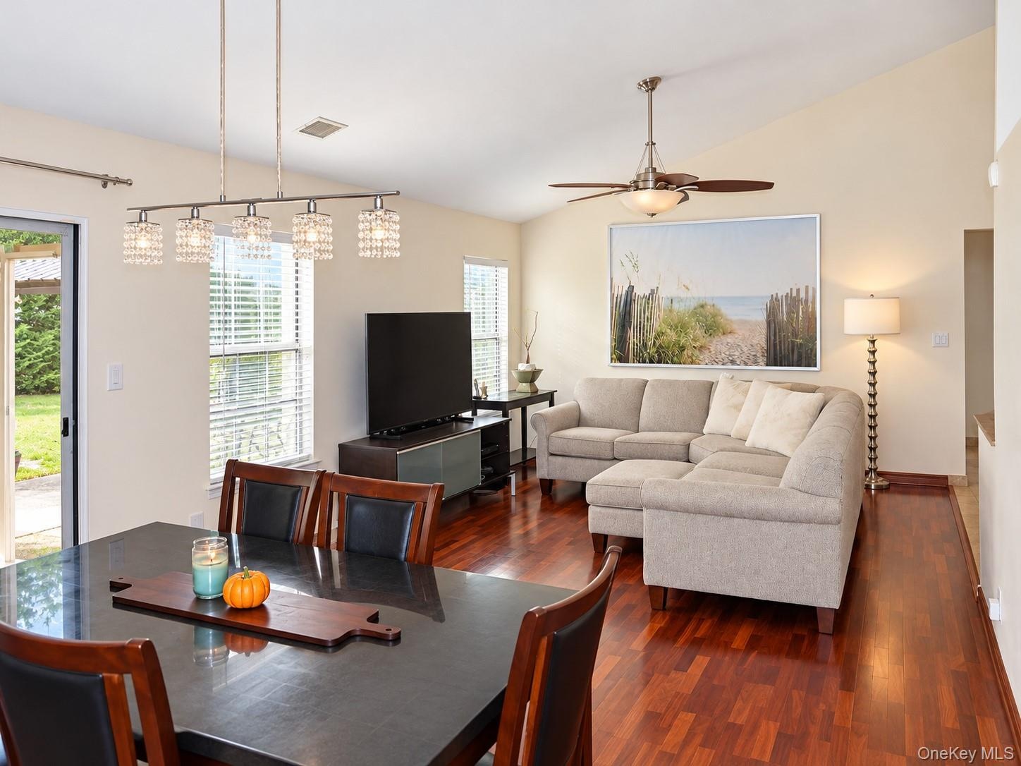 Living Room/Dining Room Vaulted ceilings complement the warm wood-finish flooring