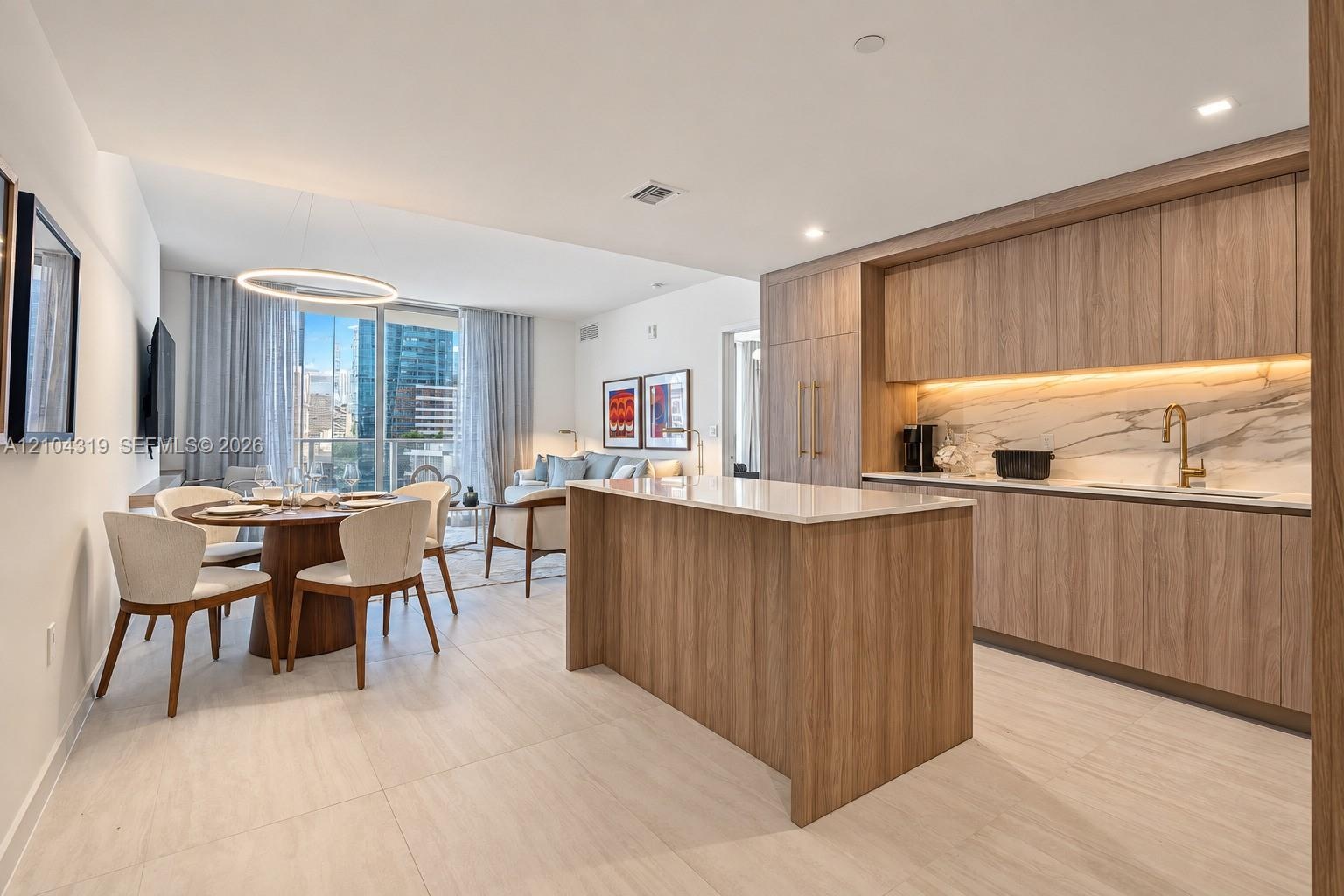 Modern kitchen featuring wood-finish cabinetry, a central island with a stone-surface countertop, integrated appliances, under-cabinet lighting, and s