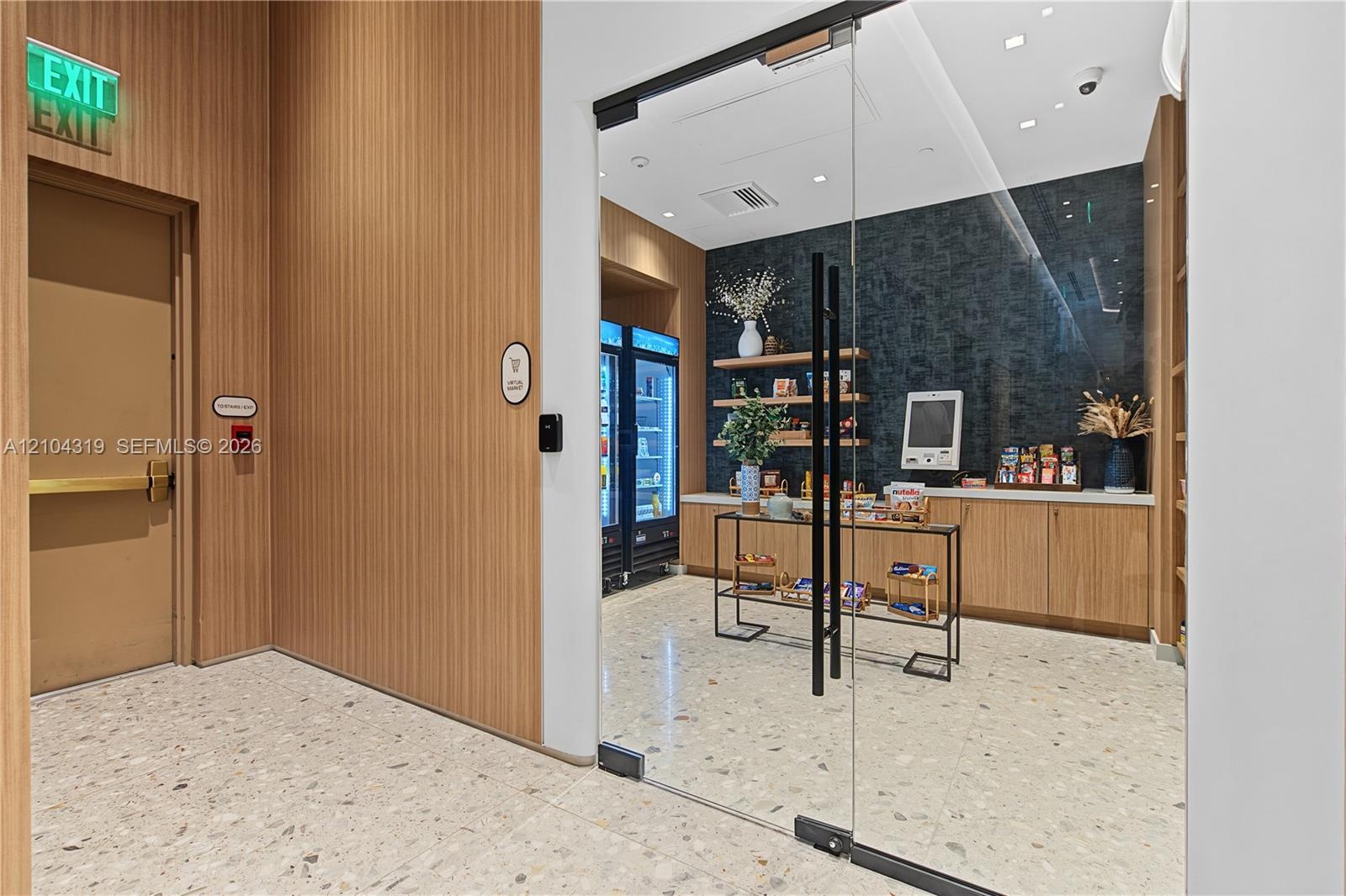 Glass-enclosed workspace featuring terrazzo flooring, light wood-finish wall paneling, built-in lower cabinetry, and recessed ceiling lighting