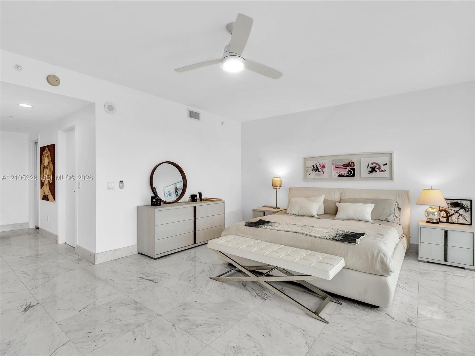 Wake up to breathtaking ocean views from the comfort of your bed in this spacious primary suite, featuring floor-to-ceiling sliding glass doors with d