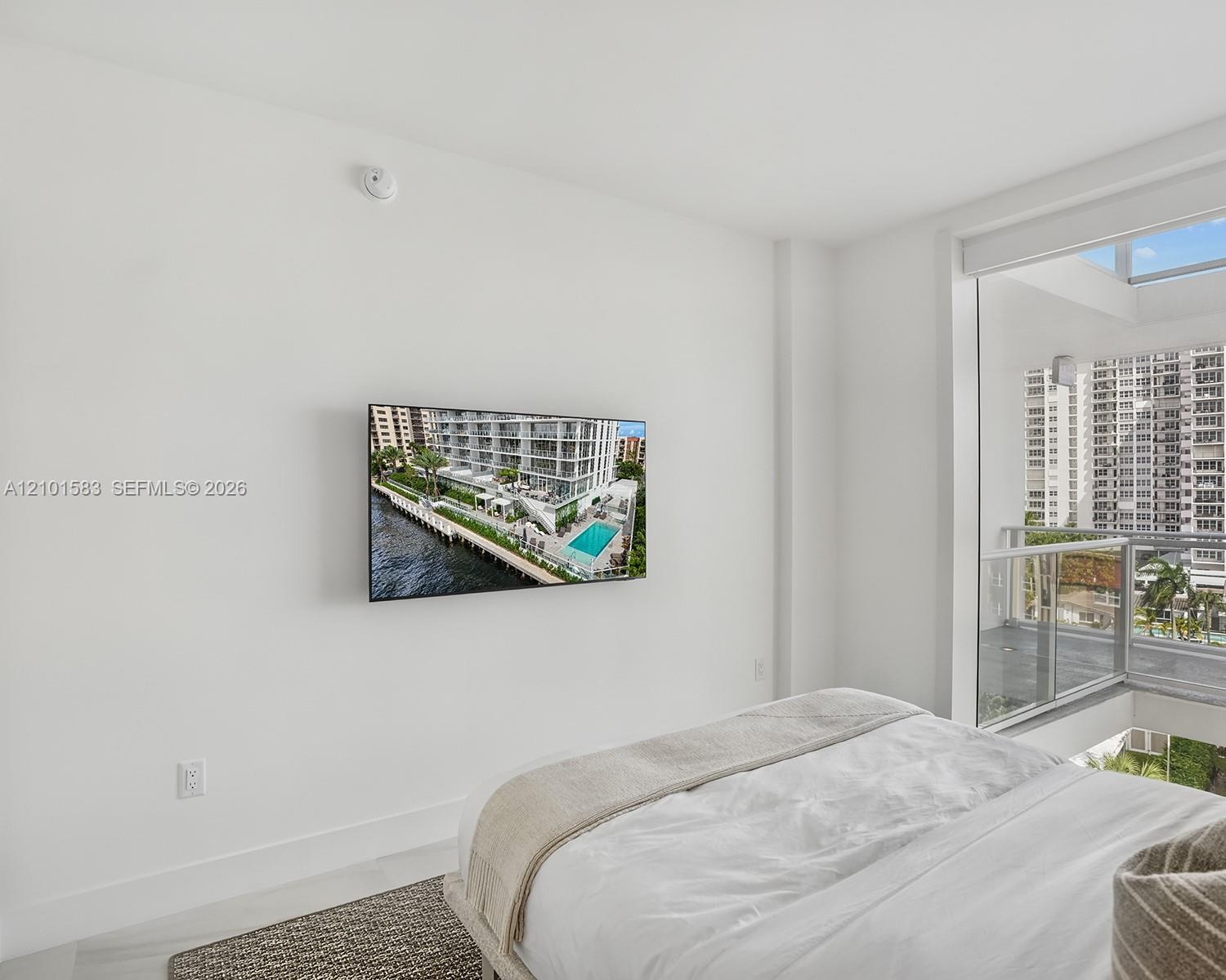 Floor-to-ceiling windows with integrated glass balcony railing and neutral flooring
