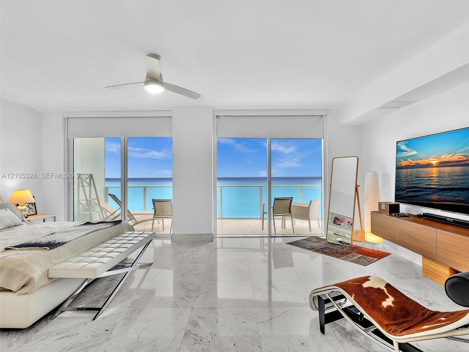 Wake up to breathtaking ocean views from the comfort of your bed in this spacious primary suite, featuring floor-to-ceiling sliding glass doors with d
