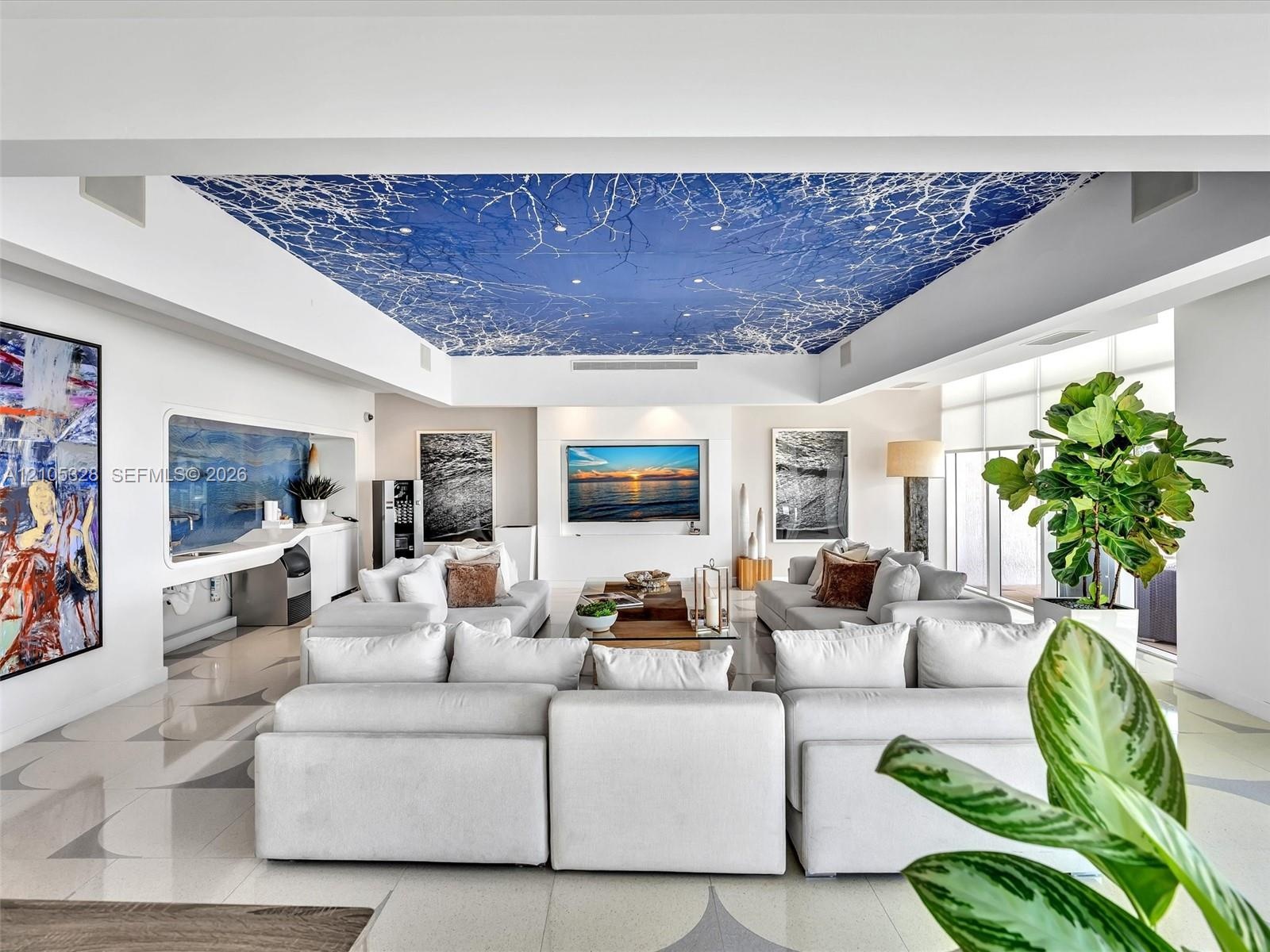 Elegant residents' lounge offering a sophisticated, boutique-style ambiance with artistic blue-and-white ceiling details, integrated speakers, illumin