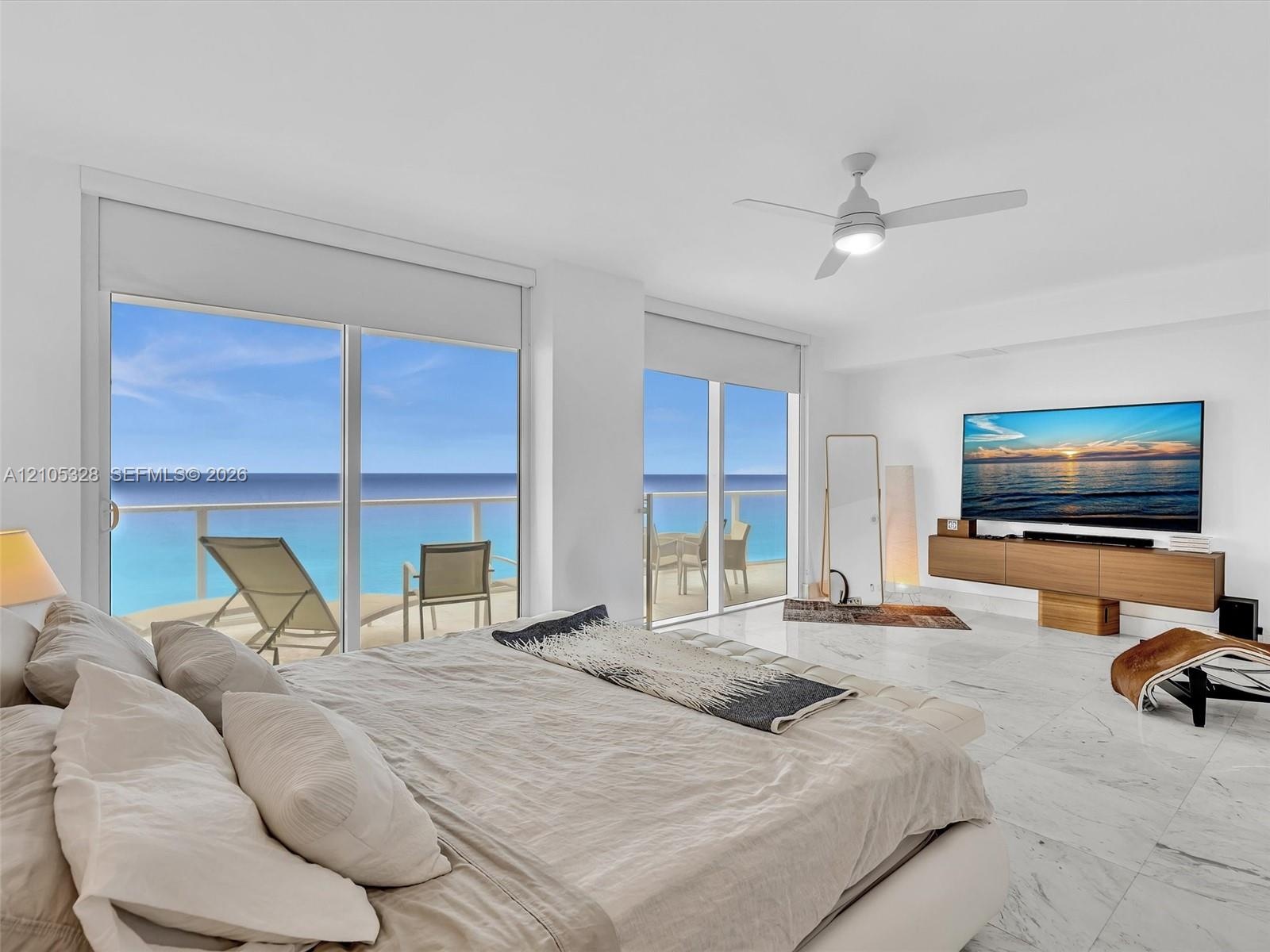 Wake up to breathtaking ocean views from the comfort of your bed in this spacious primary suite, featuring floor-to-ceiling sliding glass doors with d