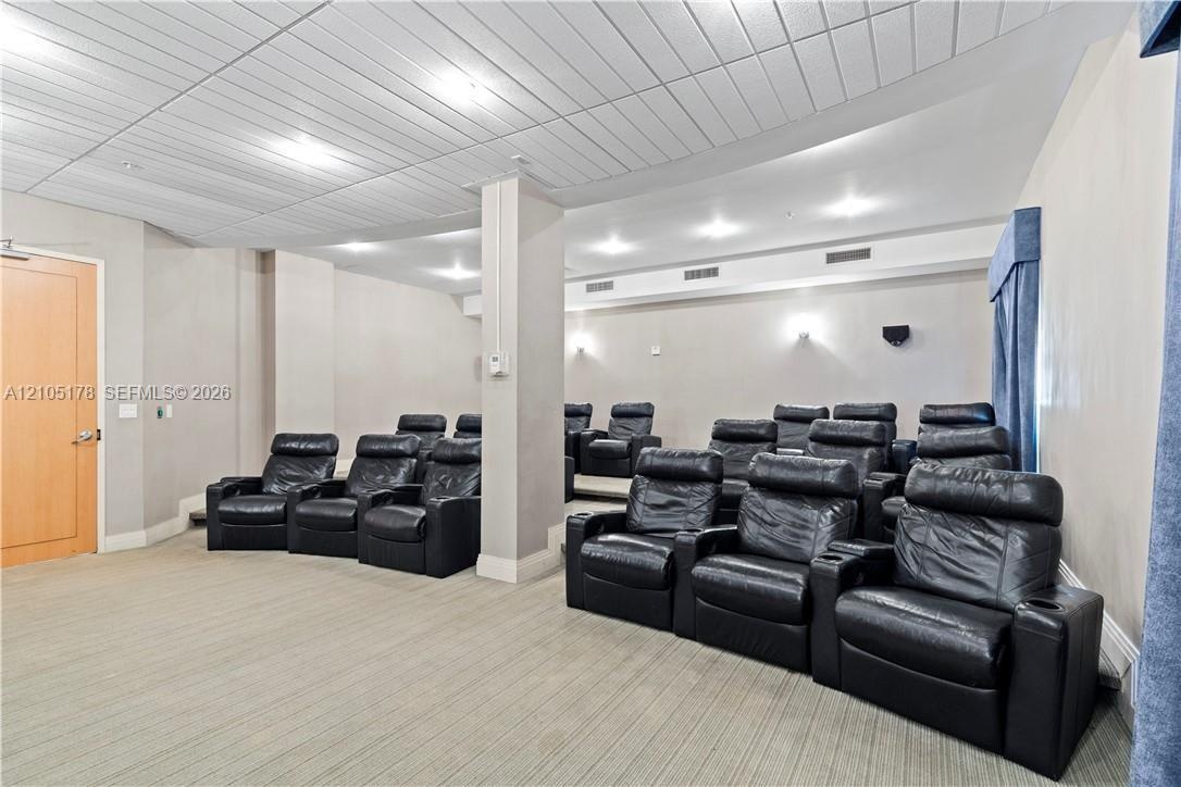 Tiered seating area featuring recessed lighting, a paneled ceiling, and neutral wall tones