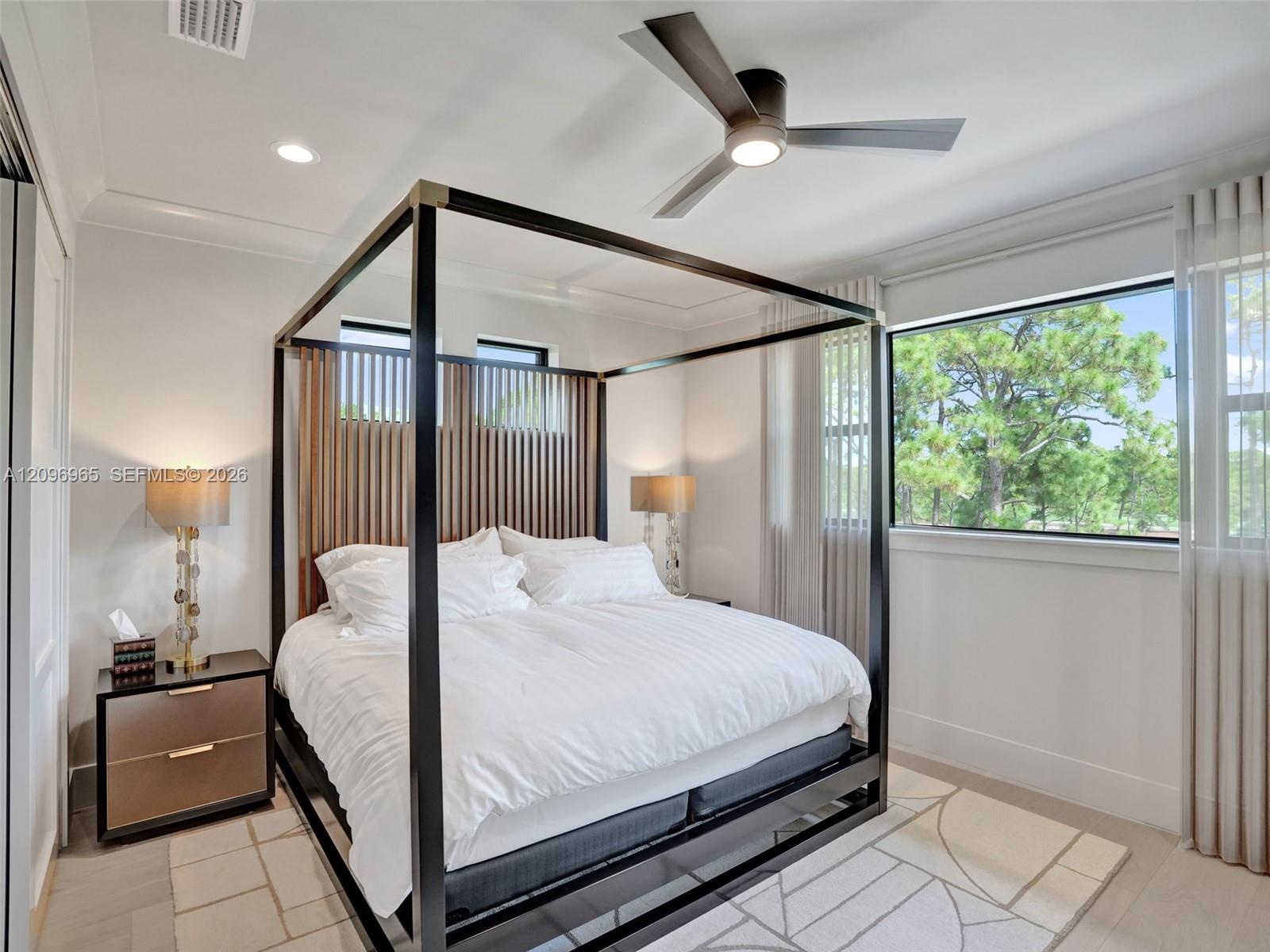Bedroom featuring recessed lighting, a multi-blade ceiling fan with integrated lighting, wood-finish flooring, and large windows with horizontal trim