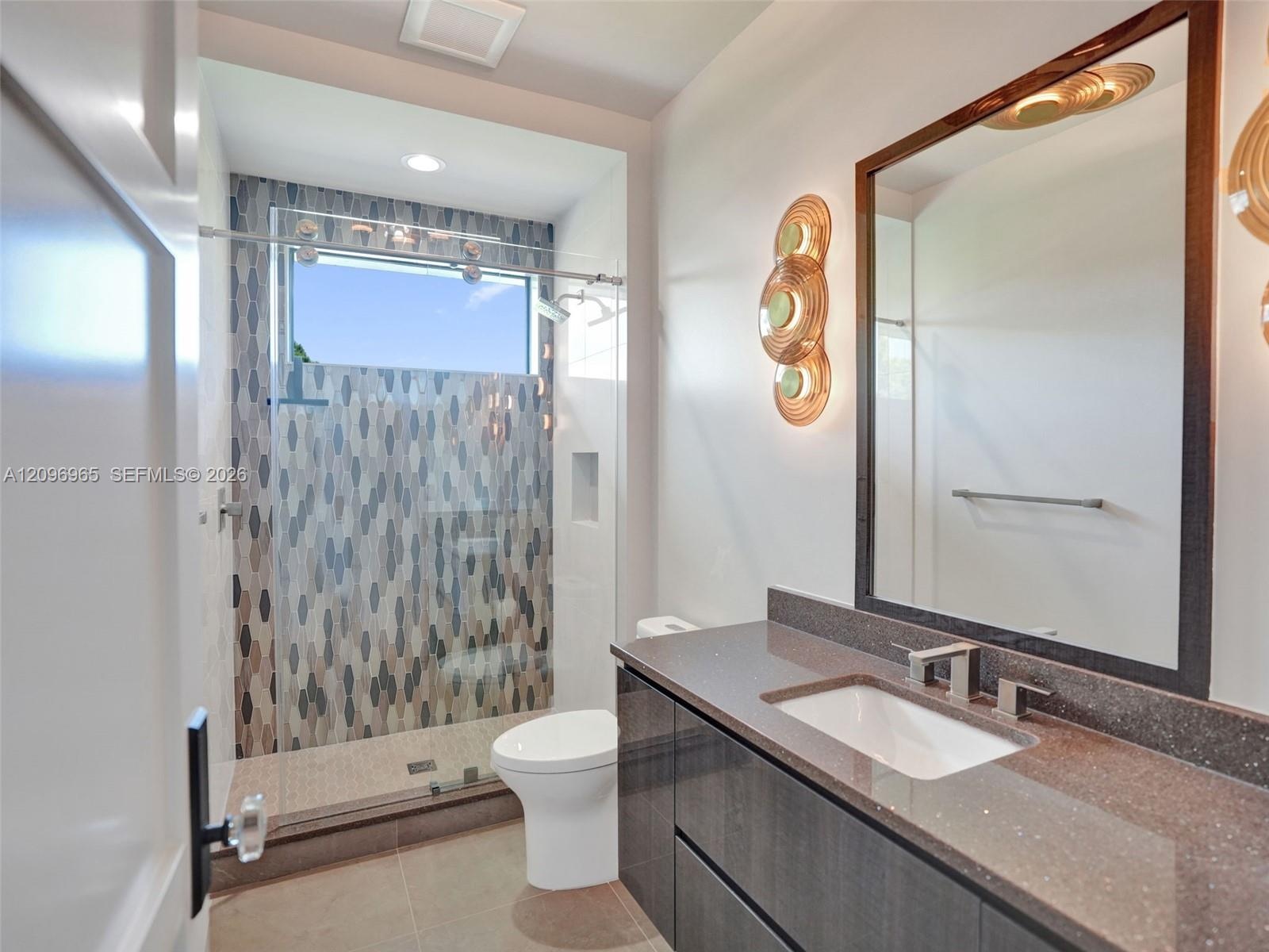 Modern vanity with a dark-toned flat-panel cabinet, solid-surface countertop, and rectangular undermount sink