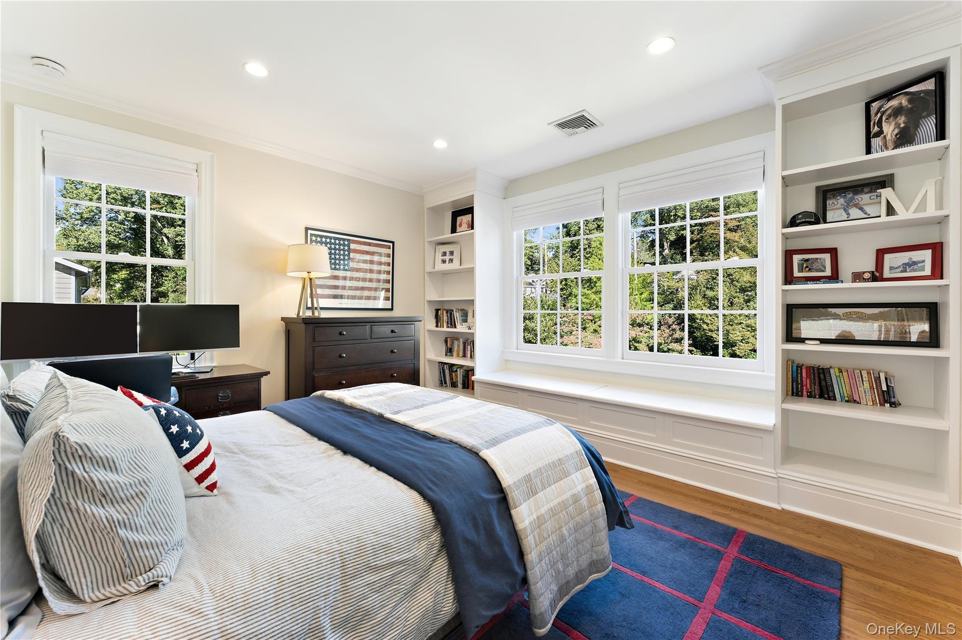 Bedroom with window seat and built-in shelving for extra storage