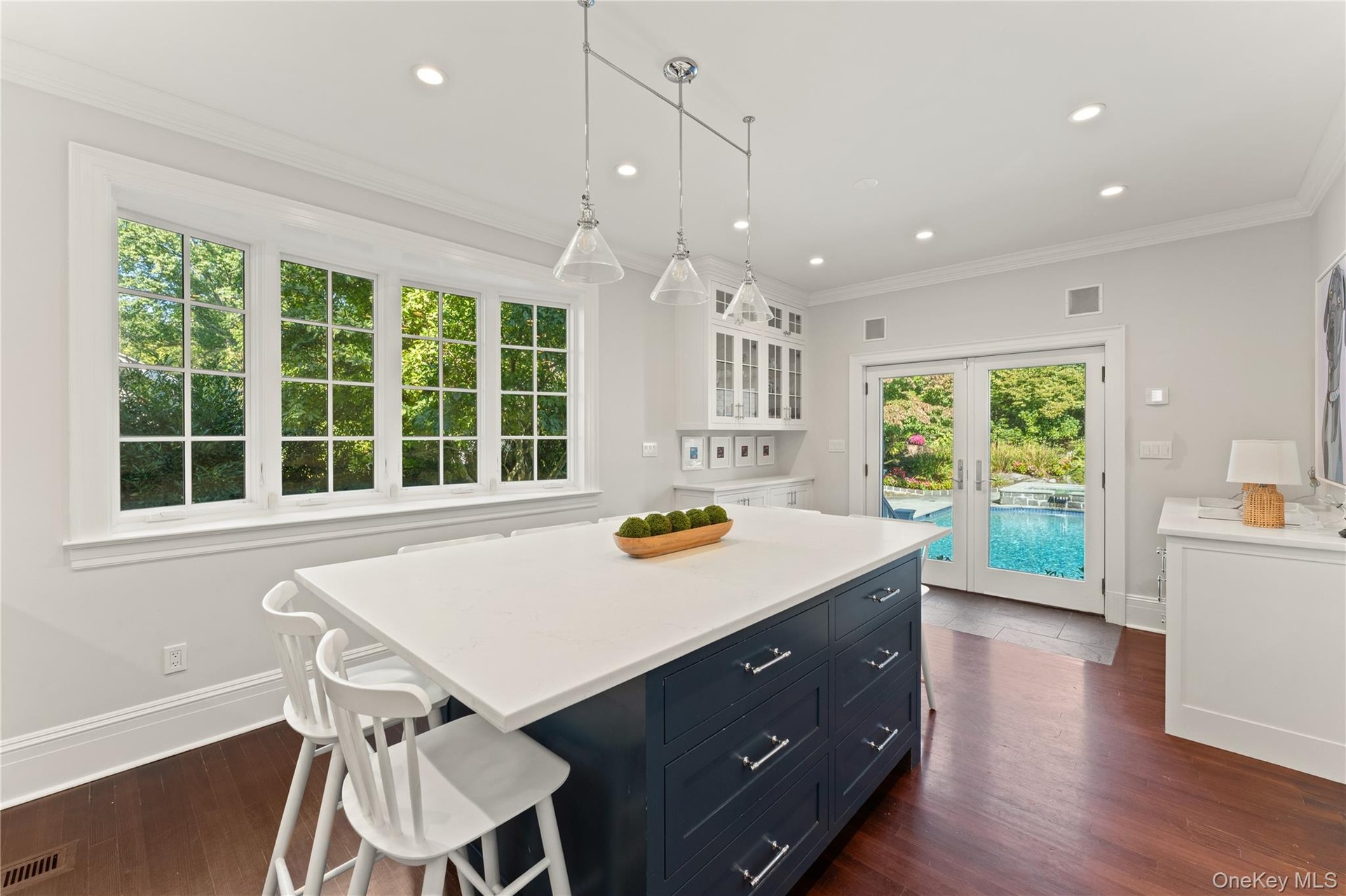 View of the sunny kitchen eat-in area looking out to the pool and gorgeous backyard