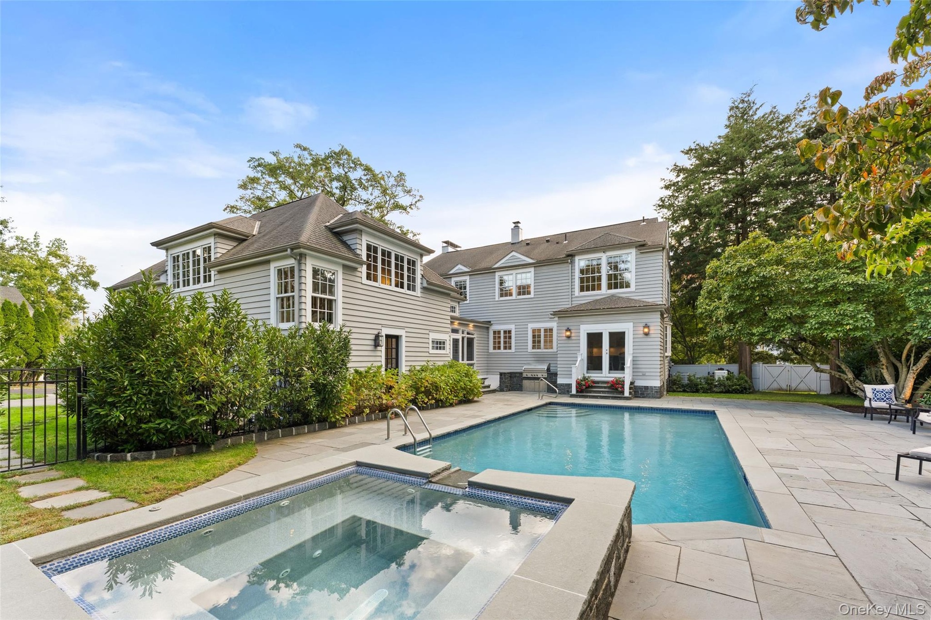 Pool and spa view showing thoughtfully designed access to the full bathroom by the garage, the kitchen, and the window-lined porch/breezeway
