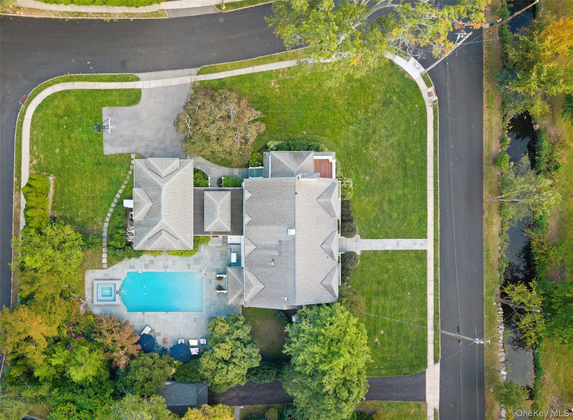 Top aerial view showcases the full breadth of the home, property size, pool and backyard