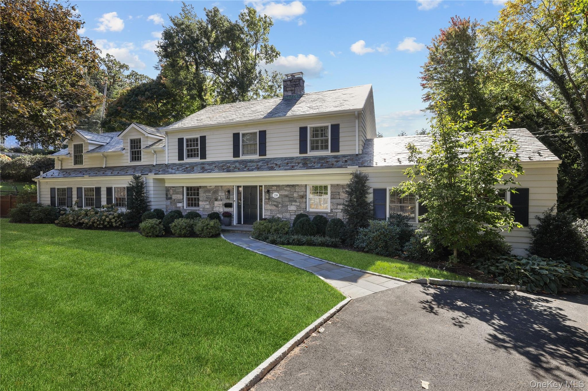 Stone veneer and siding exterior with dark shutters