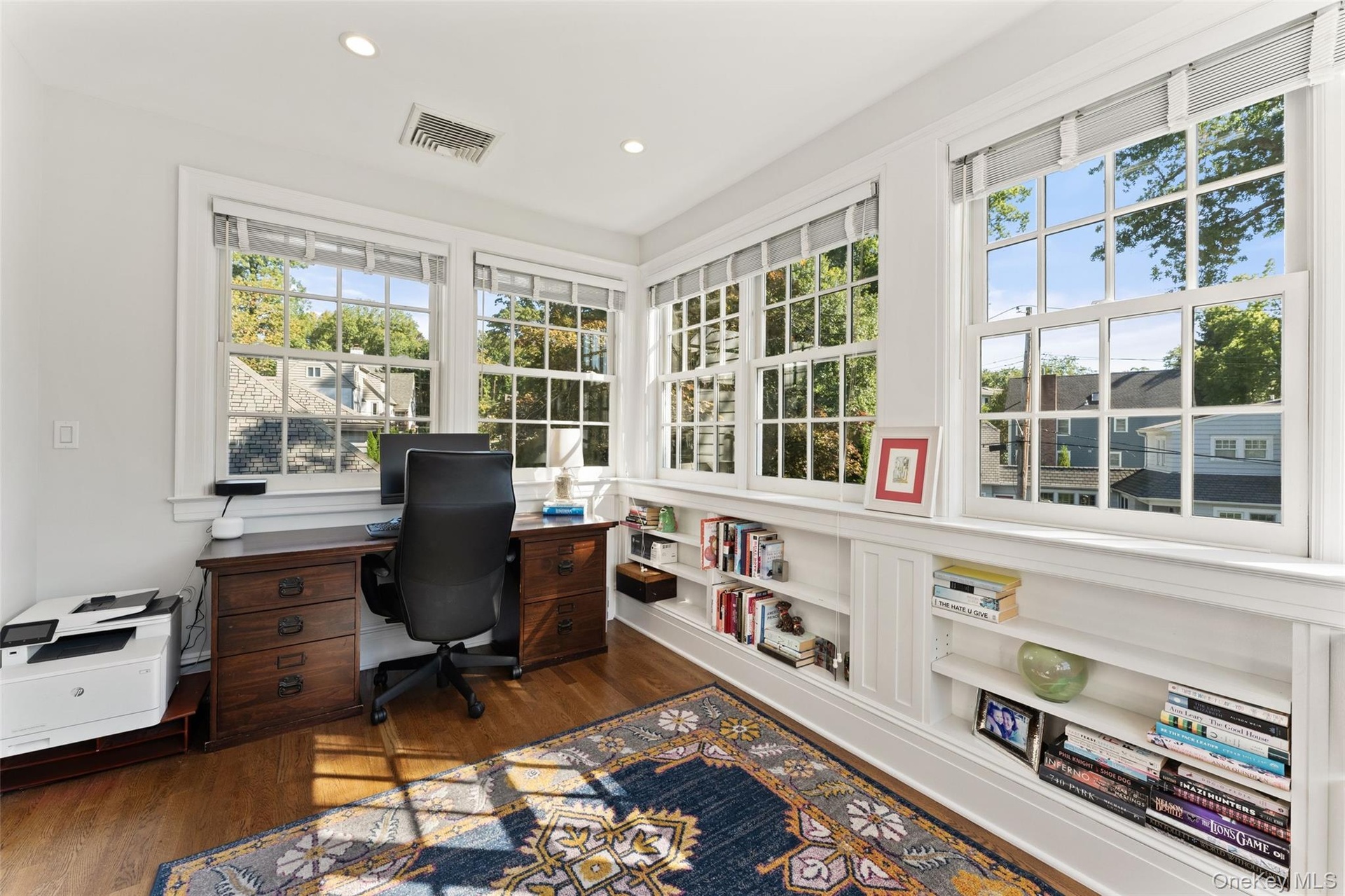 Primary bedroom office/sunroom lined with windows and enclosed with a pocket door for privacy
