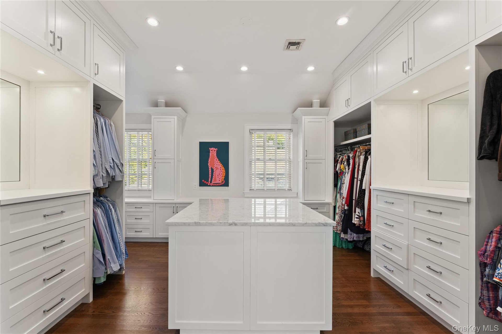 Primary bedroom his-and-hers updated walk-in closet with extensive custom cabinetry and storage