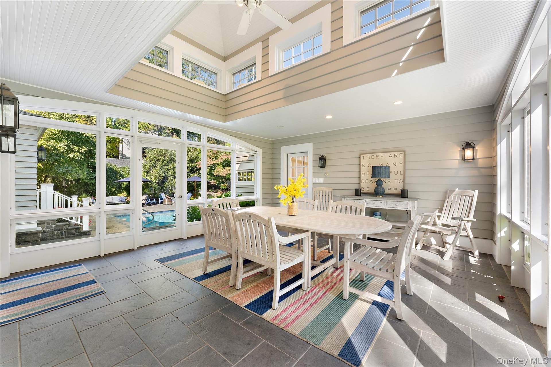 Window-lined porch/breezeway overlooks the pool, serves perfectly for indoor-outdoor entertaining, and effortlessly connects the main living spaces wi