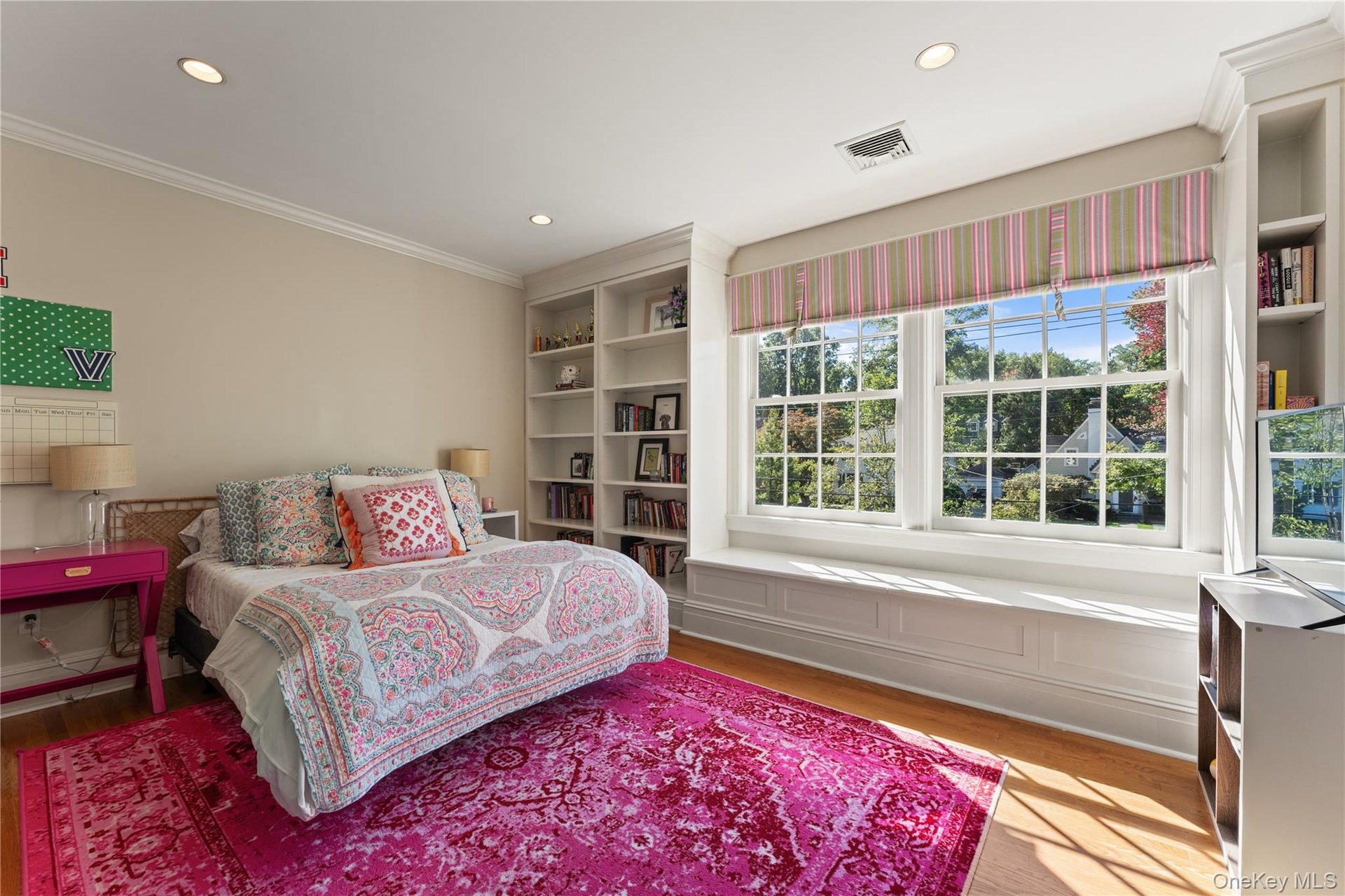 Bedroom with window seat and built-in shelving for extra storage