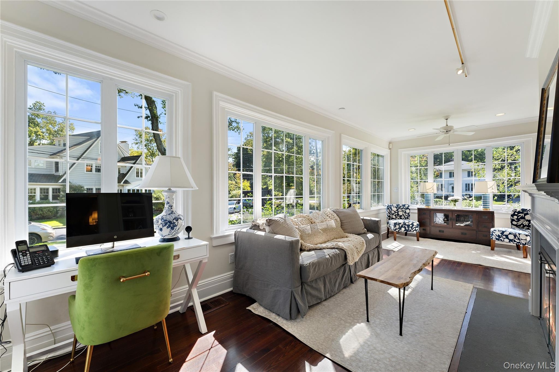 Impressive window-lined sunroom with a gas fireplace offers seamless views of the surrounding landscape