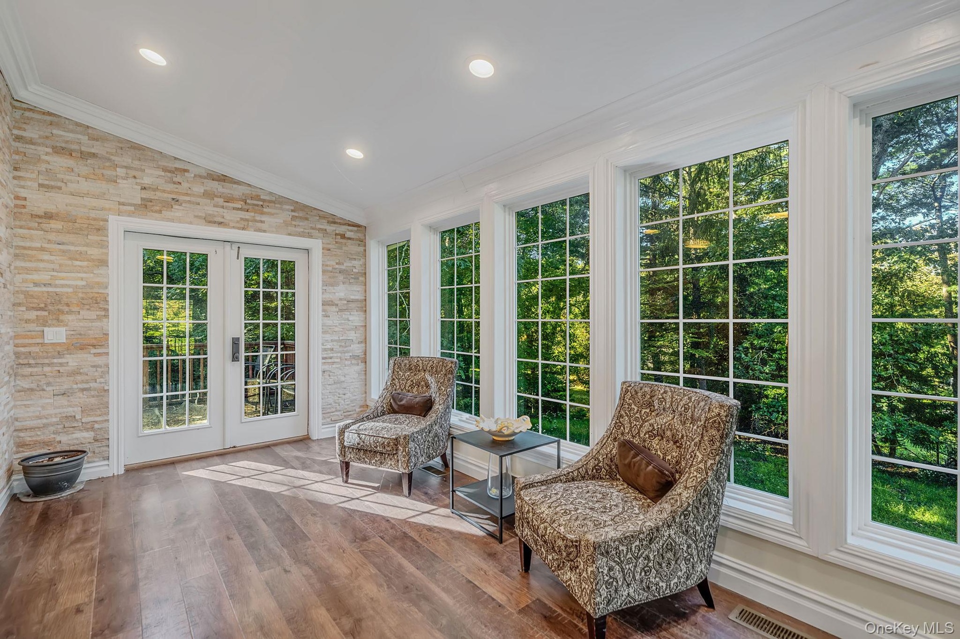 At the top of the stairs is this charming windor wrapped space with French doors to yard