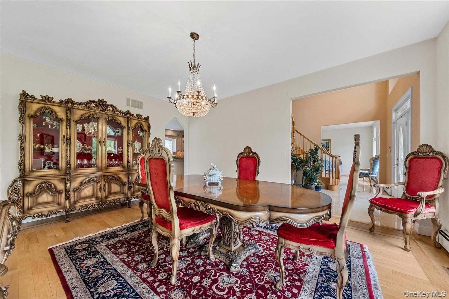 Dining area with light wood finished floors, arched walkways, and hanging lights