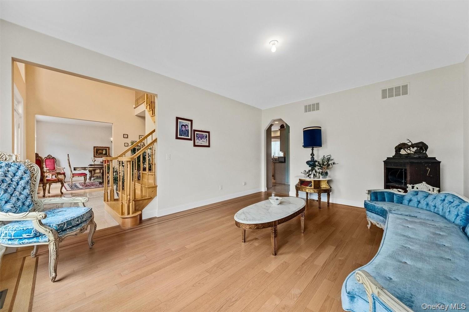 Living room with arched walkways and wood finished floors