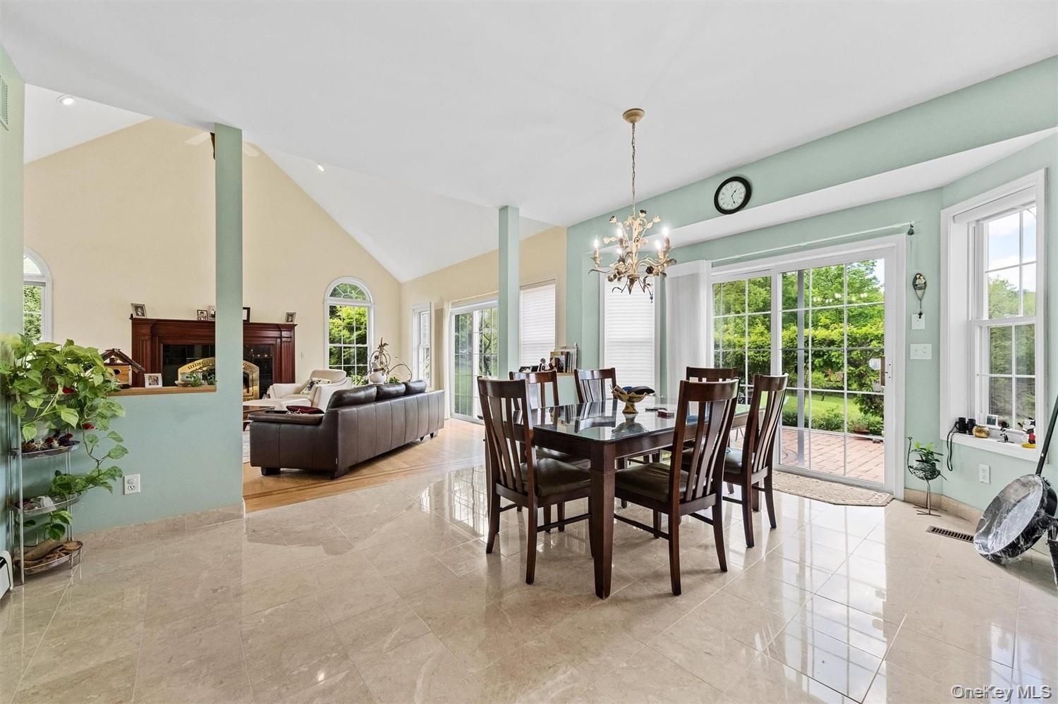 Dining area with plenty of natural light, suspended lighting, a fireplace, and lofted ceiling