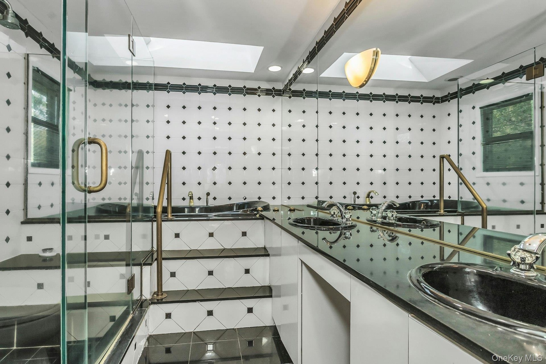 Bathroom with a skylight, a shower stall, and double vanity