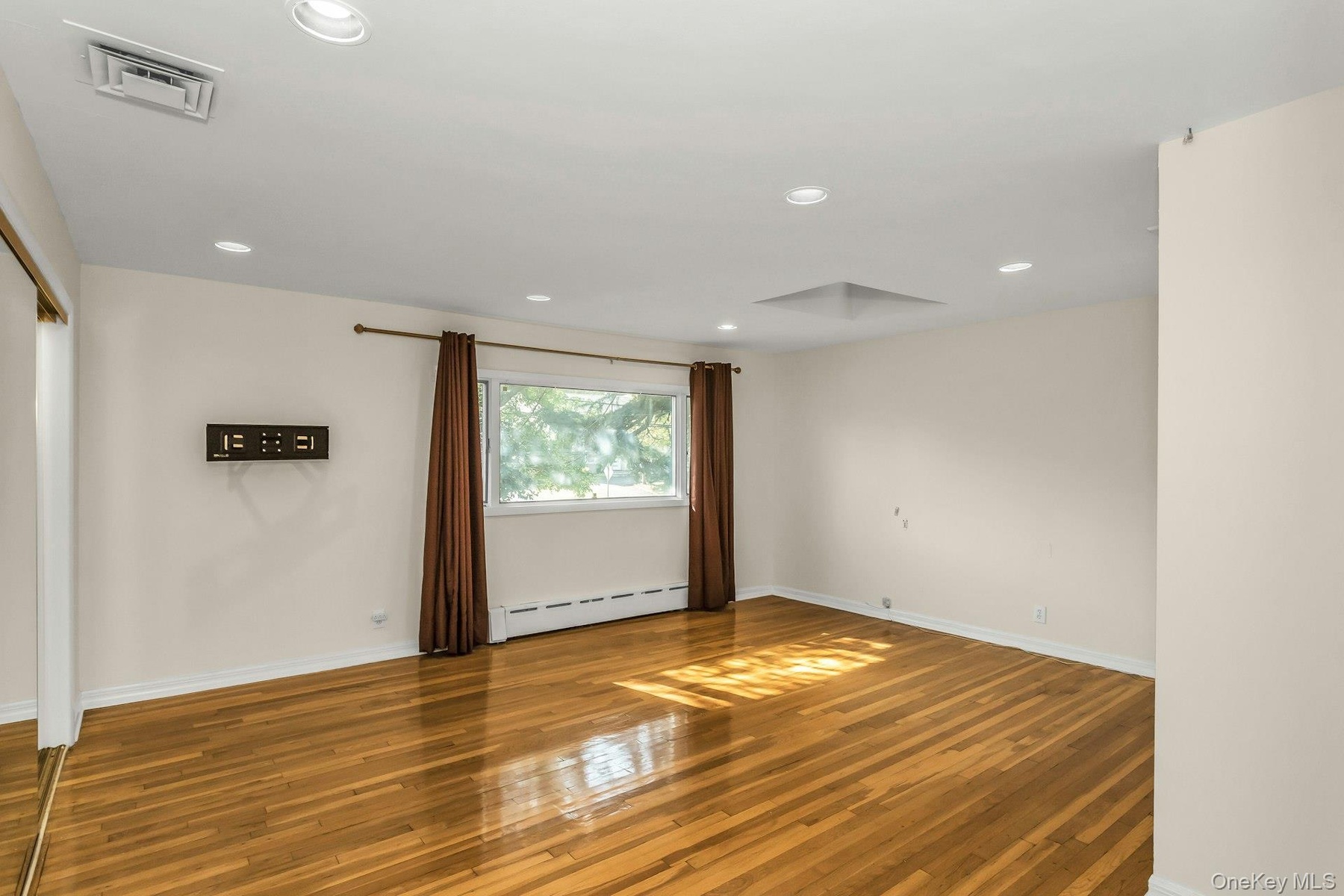 Spare room featuring light wood finished floors, recessed lighting, and baseboard heating