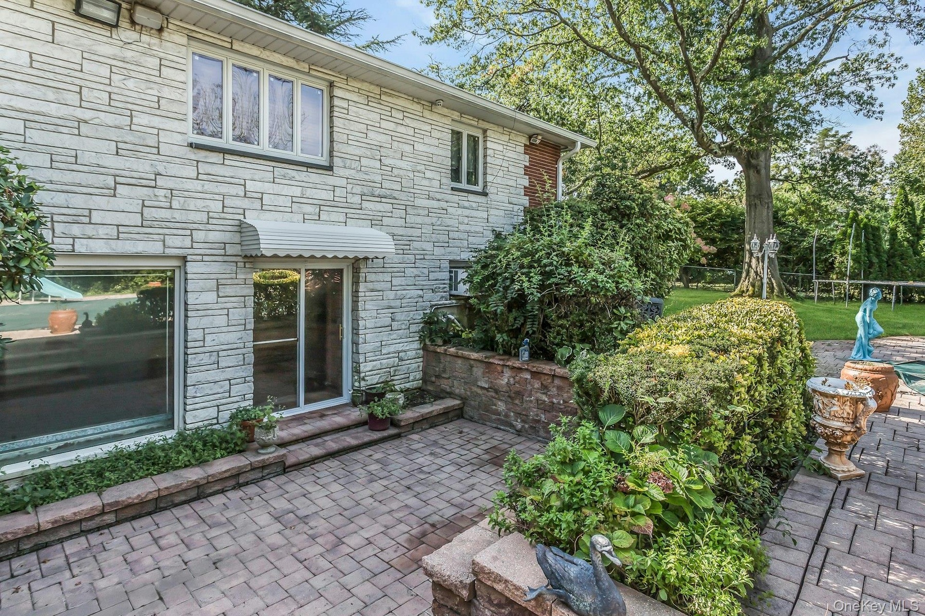 Property entrance with a patio area and stone siding