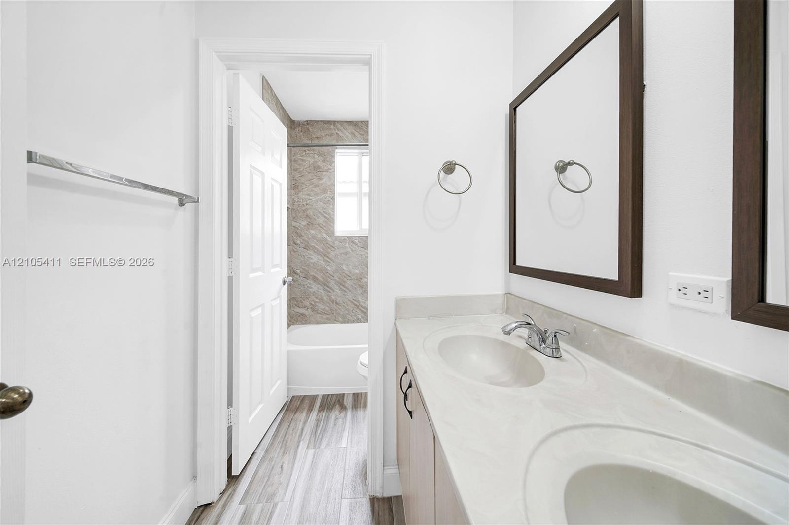 Double vanity with integrated sinks, framed mirrors, and wood-finish cabinetry