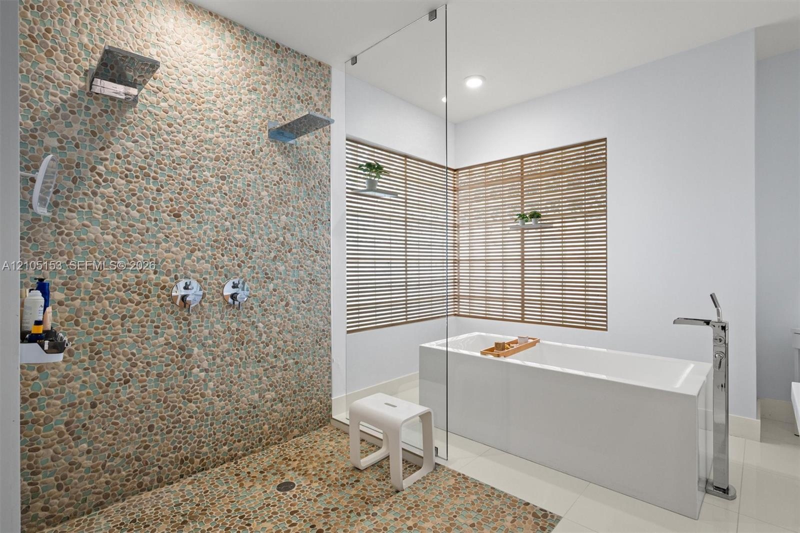 Walk-in shower with pebble tile wall and dual shower heads