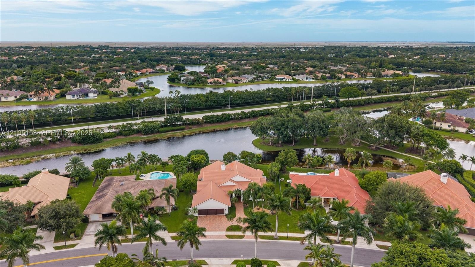 Residential community featuring multiple water features, mature trees, and varying architectural styles