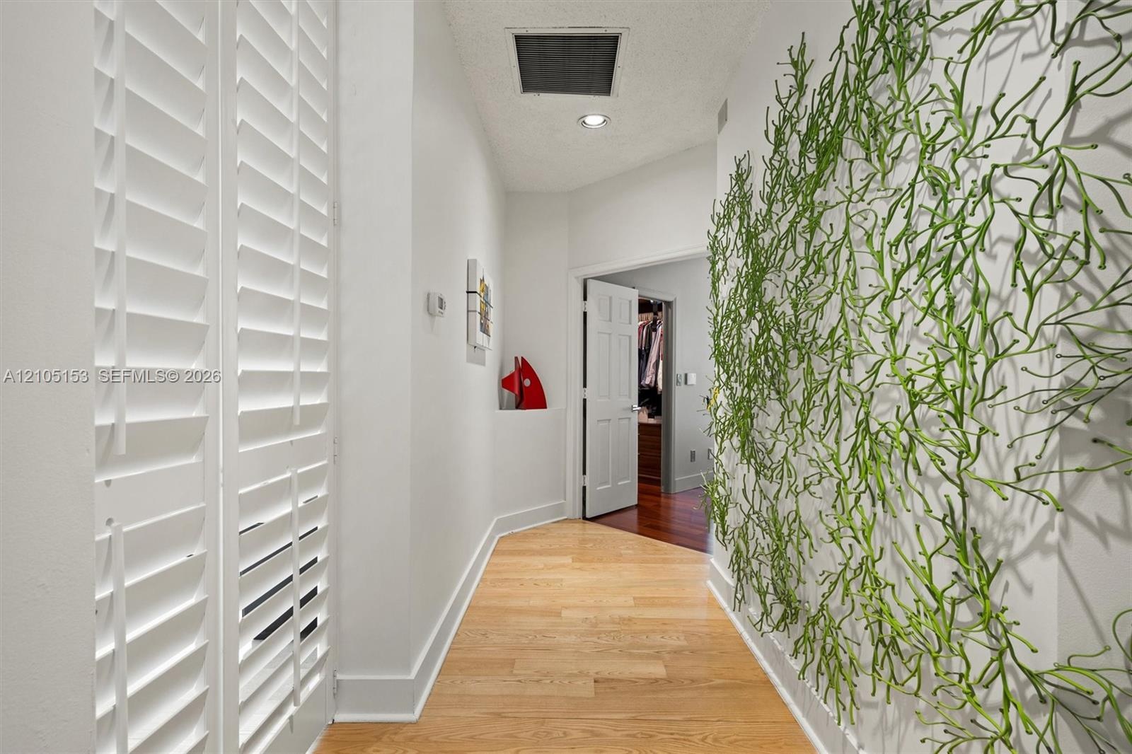 Hardwood flooring throughout, white plantation shutters, recessed lighting, and white trim