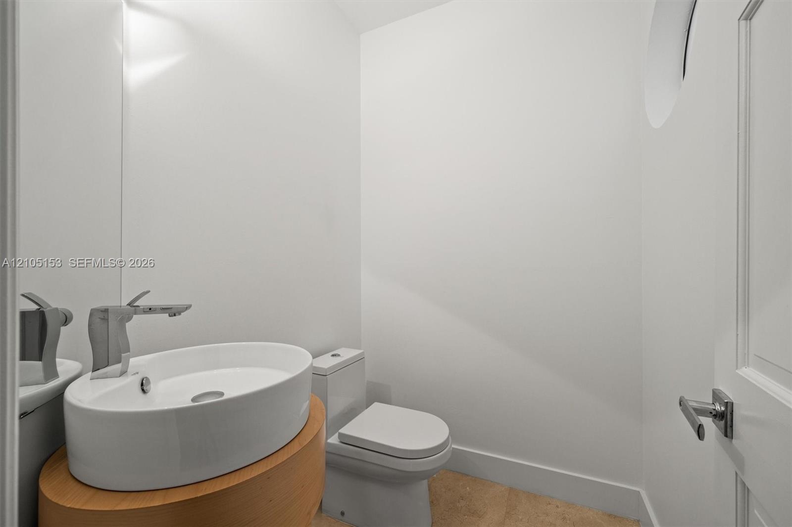 Contemporary vessel sink with a sleek chrome faucet, complemented by a wood-finish vanity
