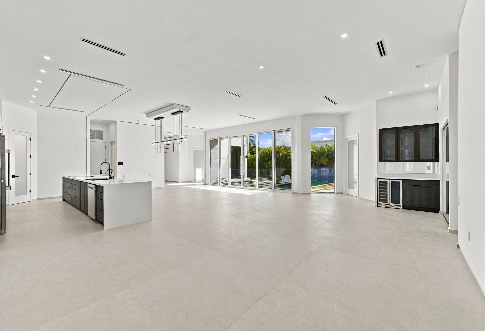 Expansive open-concept living space featuring light-toned polished concrete flooring throughout