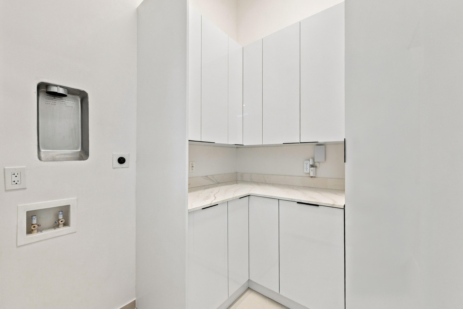 Efficient kitchenette featuring white cabinetry, light countertops, and a single-basin sink with chrome faucet