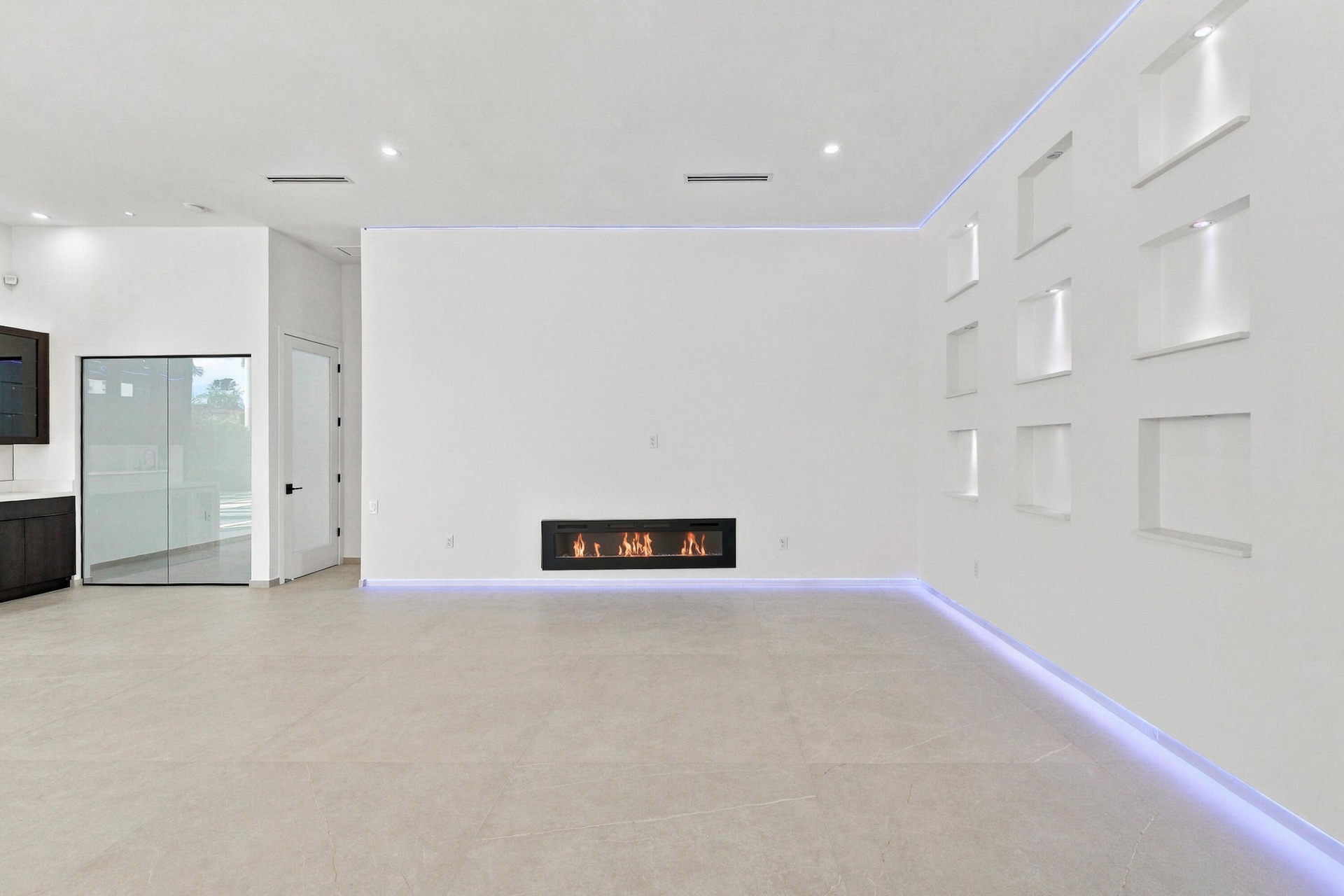 Sophisticated open-concept living space featuring light-toned polished concrete flooring, expansive white walls with architectural detail panels, rece