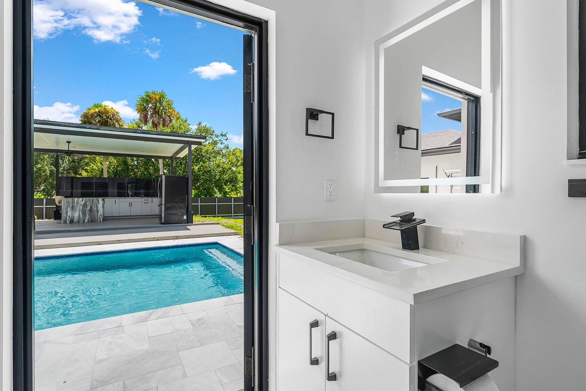 White vanity with integrated sink, quartz countertop, and matte black faucet