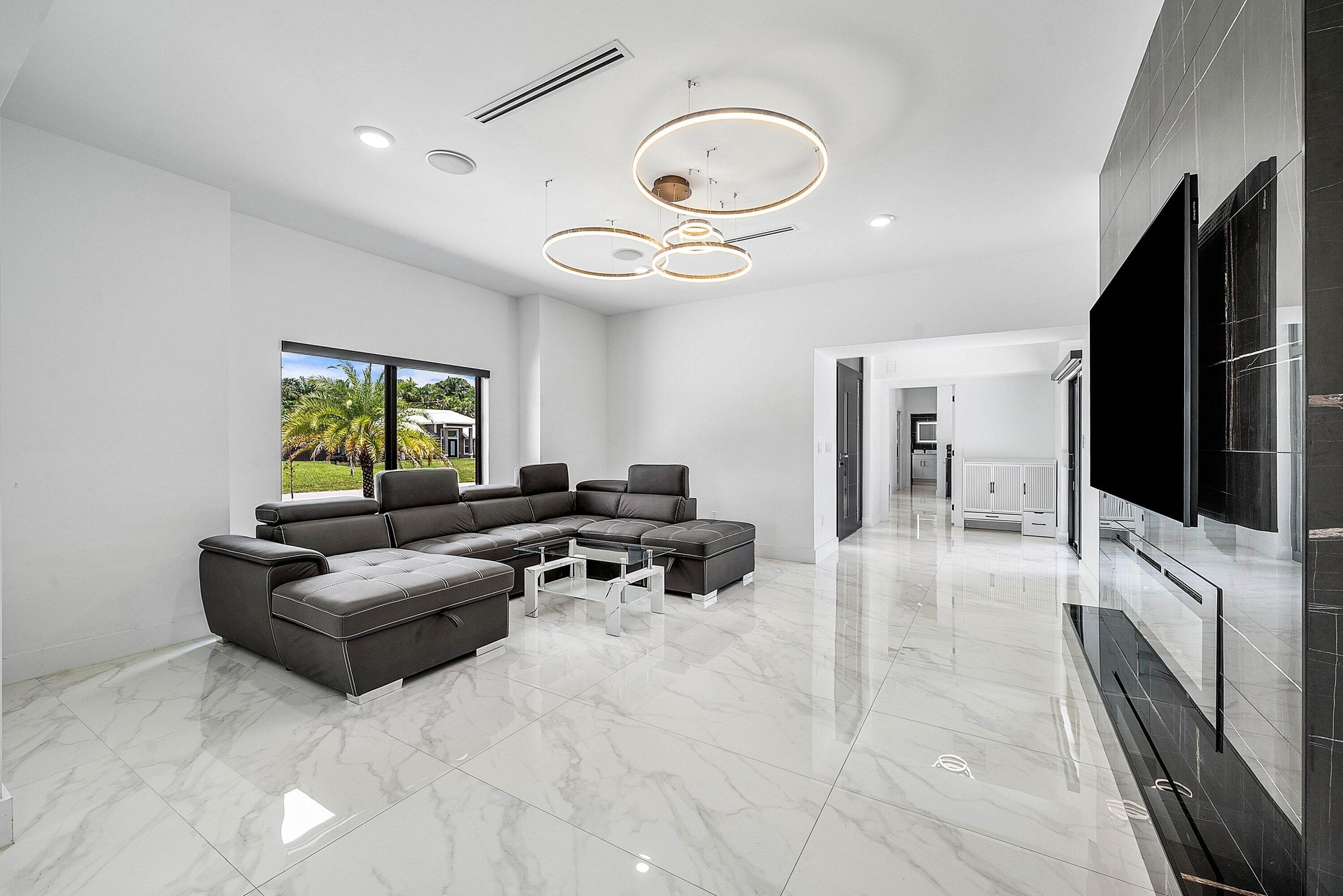 Polished tile flooring, recessed lighting, and contemporary ring chandeliers