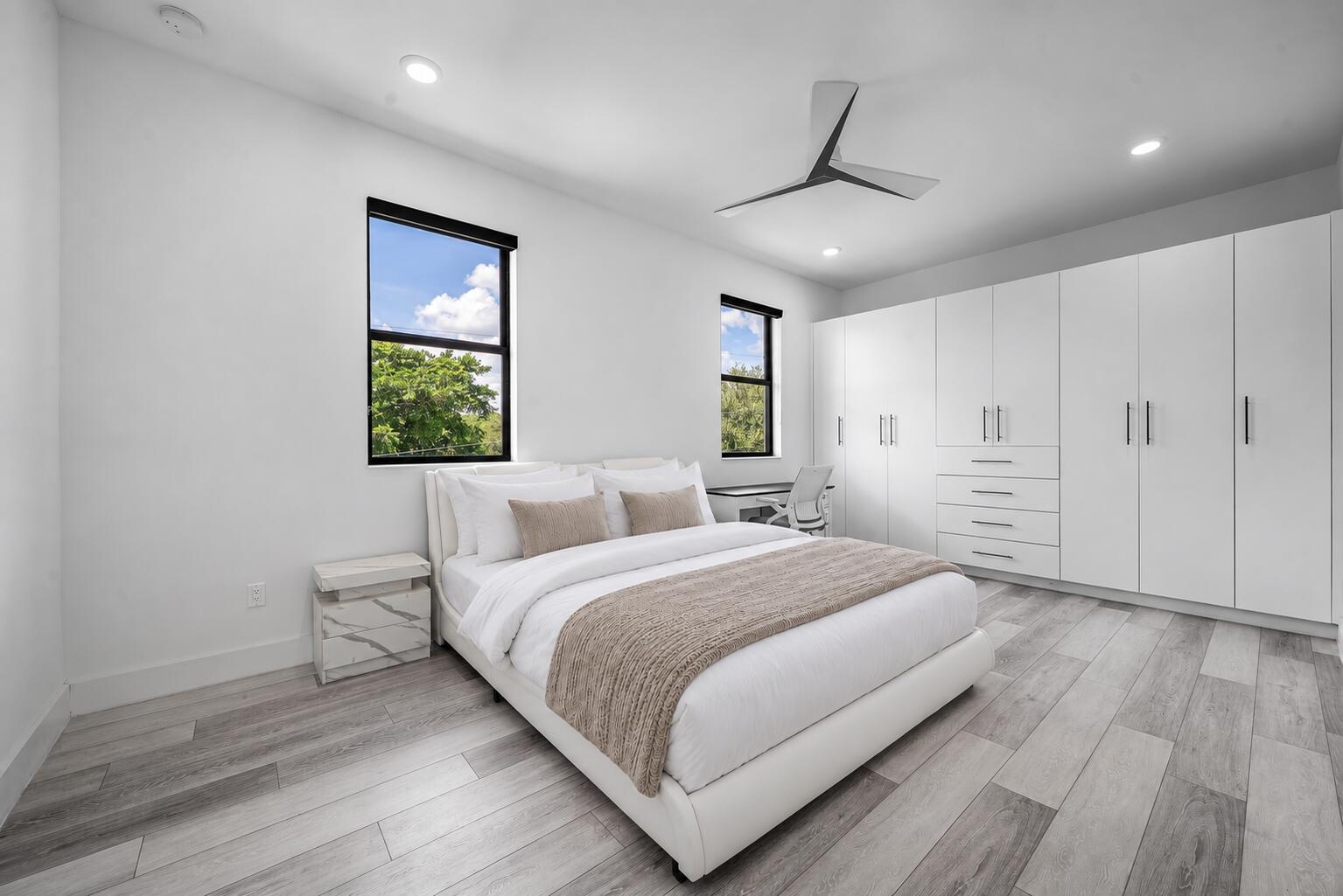 Recessed lighting, wood-finish flooring, white built-in cabinetry with drawers, and a ceiling fan with integrated lighting