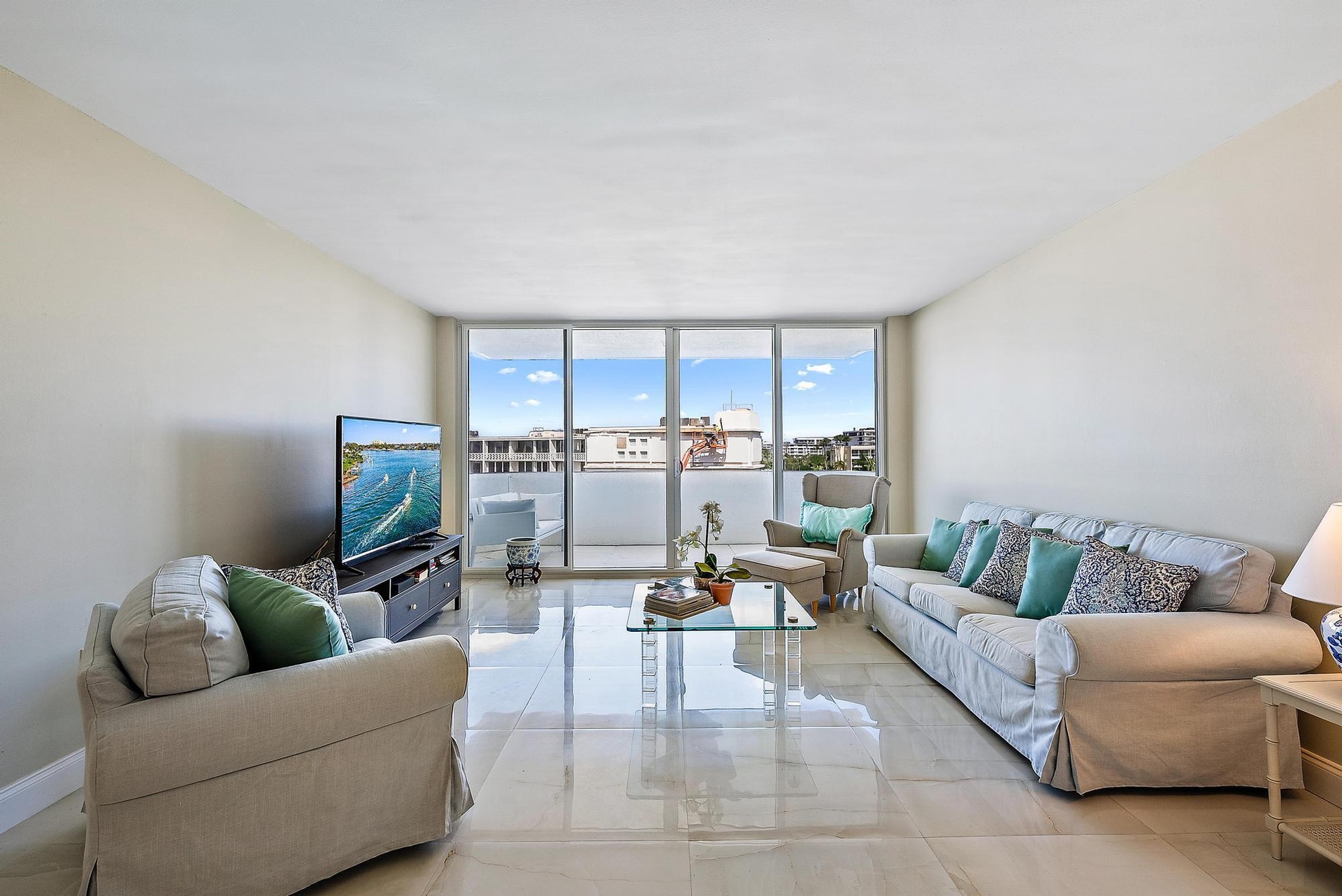 High-gloss tile flooring, floor-to-ceiling glass doors, and a private balcony