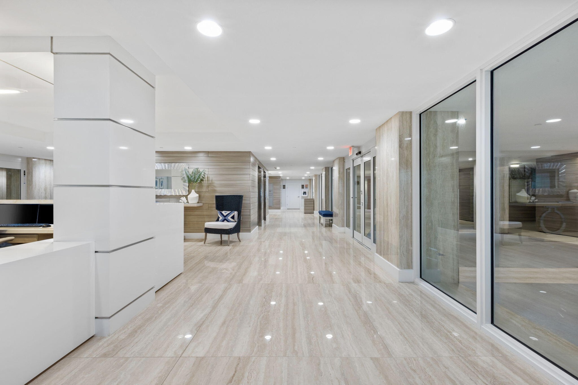 Reflective tiled flooring, recessed lighting, wood-finish wall panels, and full-height glass partitions