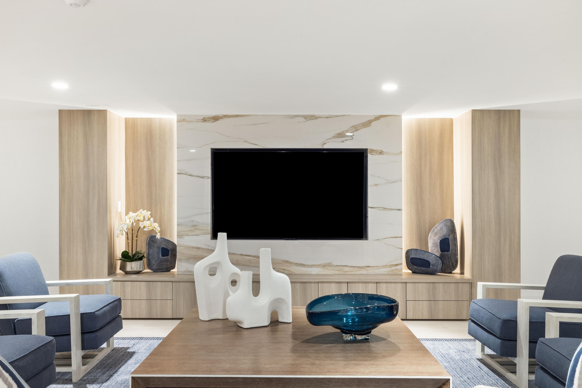 Built-in media console with wood-finish cabinetry, integrated shelving, and a stone-look accent wall