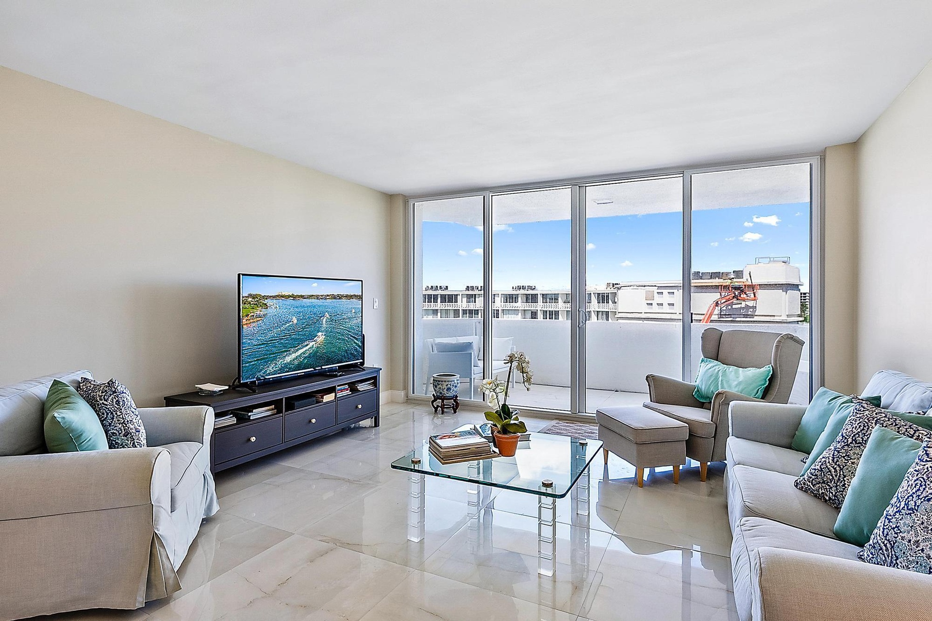 Expansive glass sliding doors to balcony, light-toned wall color, and polished tile flooring