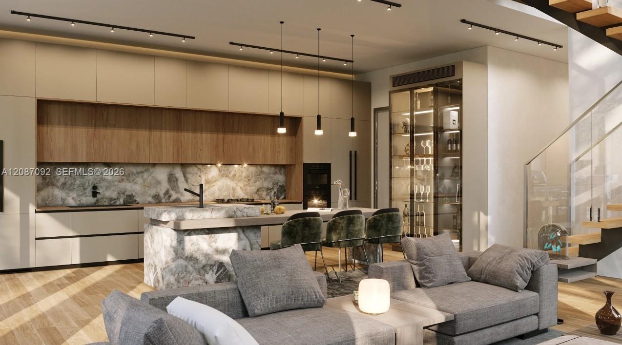 Open-concept living space with wood-finish flooring, a contemporary kitchen featuring integrated appliances and stone slab backsplash, a built-in glas