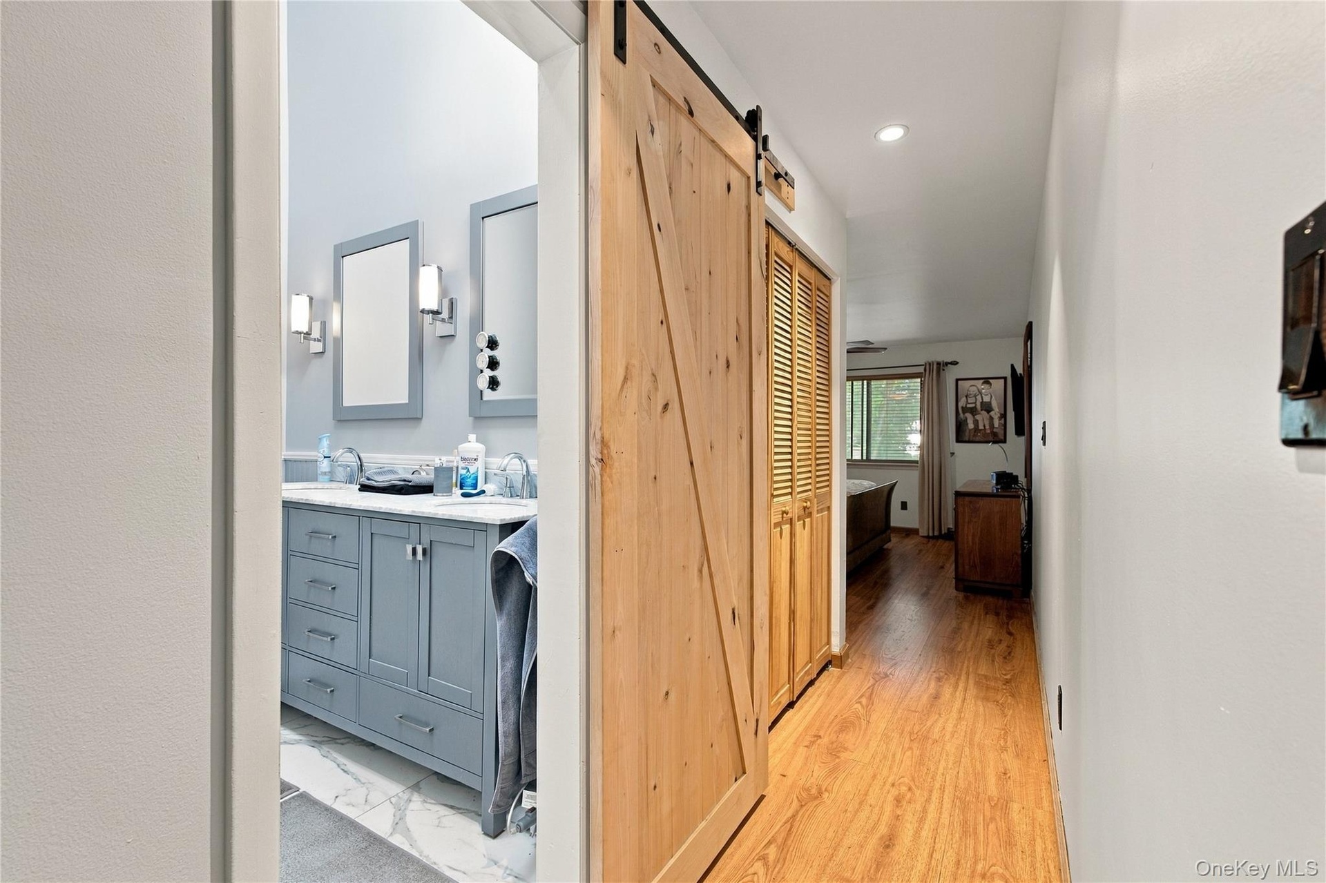 Primary Suite w/view of modern bathroom w/skylight and barn door and double closet