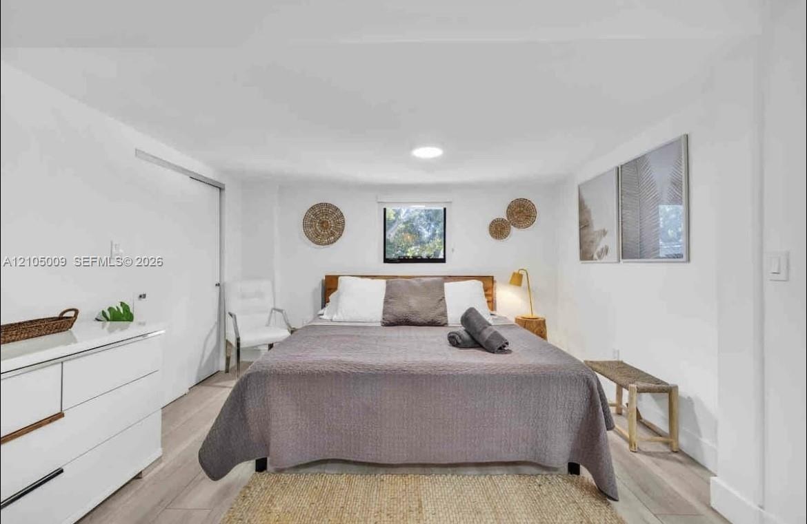 Light wood-finish flooring, white walls, and a recessed ceiling light