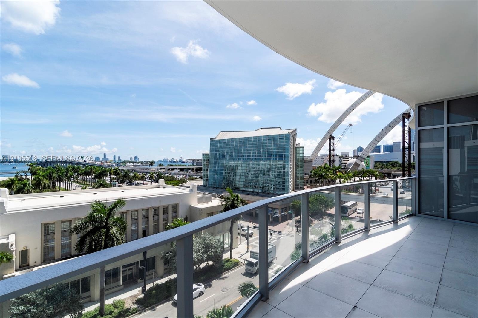 Balcony featuring glass railings, a tiled floor, and a curved ceiling