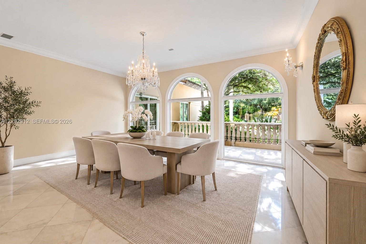 Formal dining space featuring arched glass doors, a crystal chandelier, tiled flooring, and crown molding