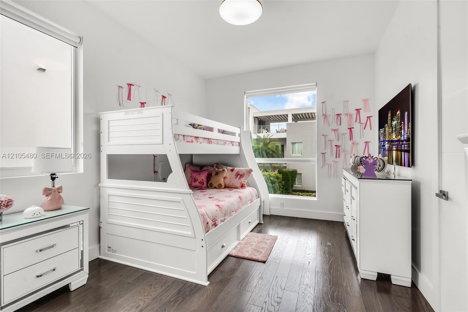 Rich wood-finish flooring, bright white walls, and recessed lighting