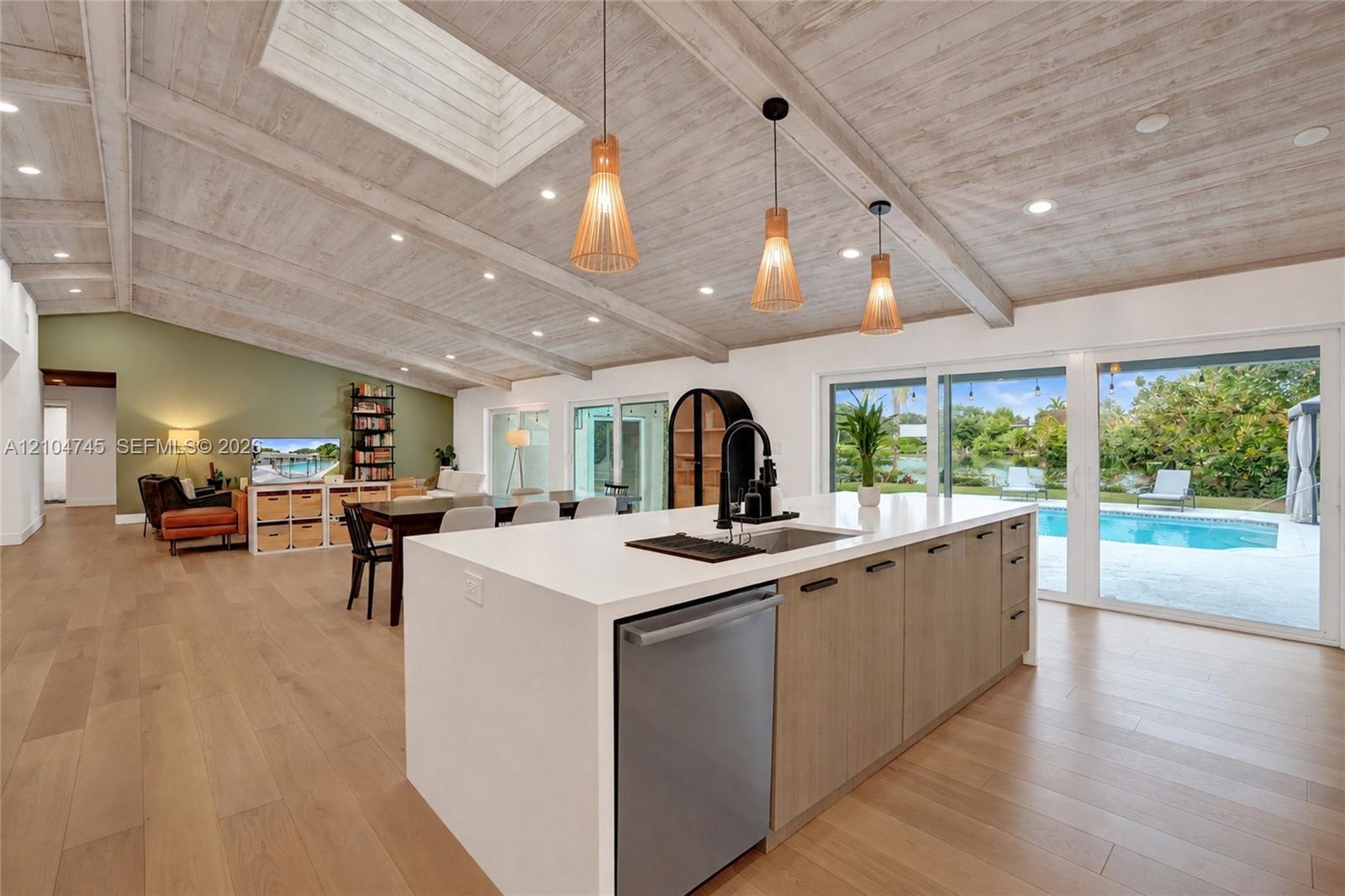 Vaulted wood-finish ceiling with exposed beams and recessed lighting